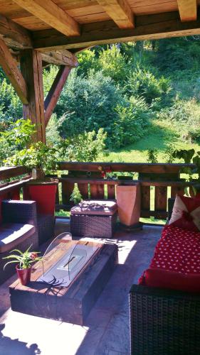 a patio with chairs and tables and a wooden roof at Chambres d'Hôtes Chalet de la Source in Morillon