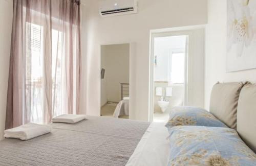 Habitación blanca con cama y ventana en Lea's House independent solution, en Nápoles