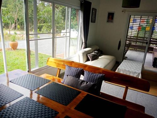 ein Wohnzimmer mit Sofa und Tisch in der Unterkunft Sunbeam Cottage in Ko Chang