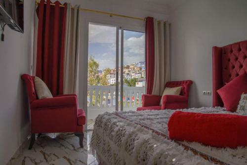 una camera con un letto e due sedie e una finestra di Hotel Princesse Ilham a Chefchaouen