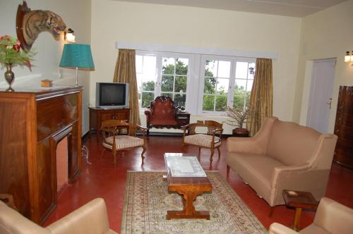 un salon avec un canapé et une télévision dans l'établissement Ama Plantation Trails, Chikmagalur, à Chikmagalur