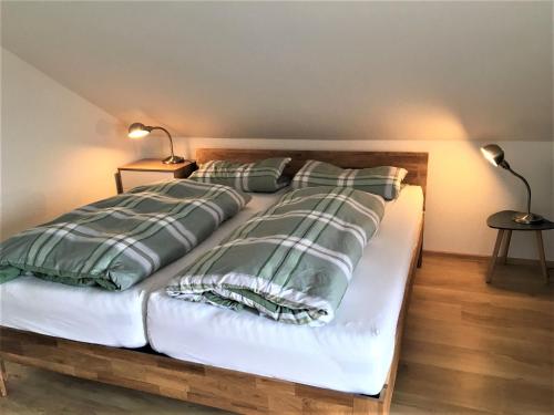a bed with four pillows on it in a room at Eulennestle in Lenzkirch