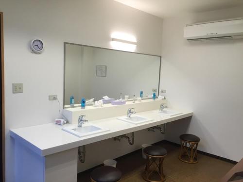 a bathroom with two sinks and a large mirror at Hamamura Onsen Totoya in Tottori