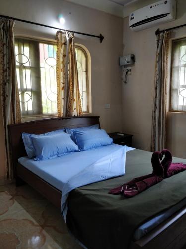 a bedroom with a large bed with blue pillows at Koito-House calangute guest house in Calangute