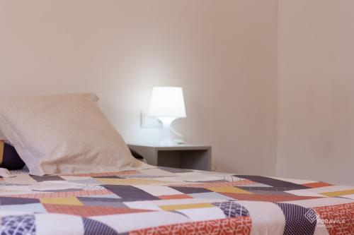 a bed with a pillow and a table with a lamp at Casa Embat in Can Picafort
