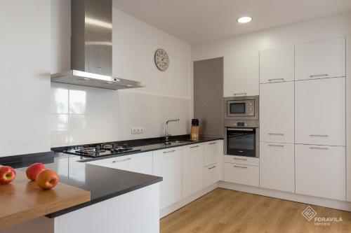 a kitchen with white cabinets and a counter with apples on the counter at Casa Embat in Can Picafort