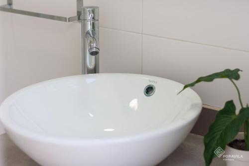 a white sink in a bathroom with a plant at Casa Embat in Can Picafort
