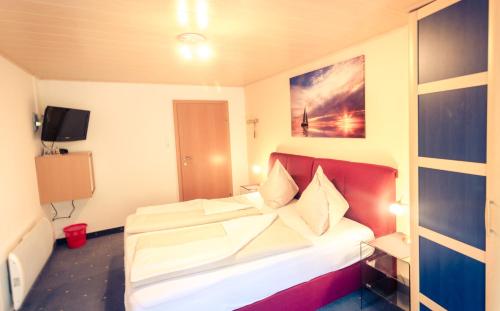 a bedroom with a bed in a room with a tv at Pension Waldruh - Tannenheim in Faak am See