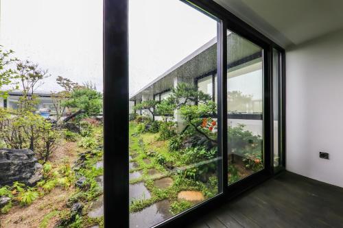 a room with a window looking out at a garden at Seosan Aria Hotel in Seosan