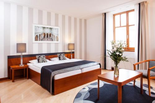 ブダペストにあるHapimag Resort Budapestのベッドとテーブルが備わるホテルルームです。