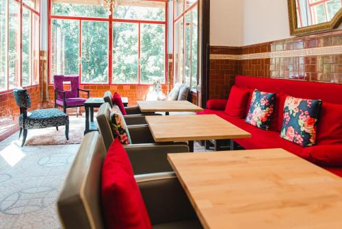 een restaurant met rode banken en tafels en ramen bij Hotel Torre Barcelona in Sant Cugat del Vallès