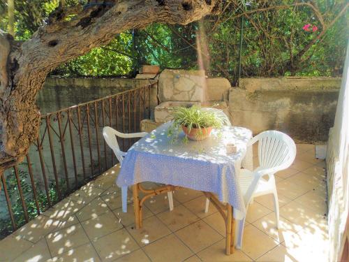 a table with two chairs and a potted plant on it at Guidaloca Bay House con mini-piscina Scopello in Castellammare del Golfo