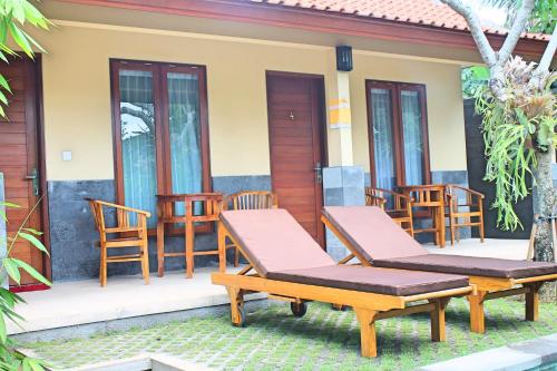 a pair of chairs on the porch of a house at Werkudara Guest House in Ubud