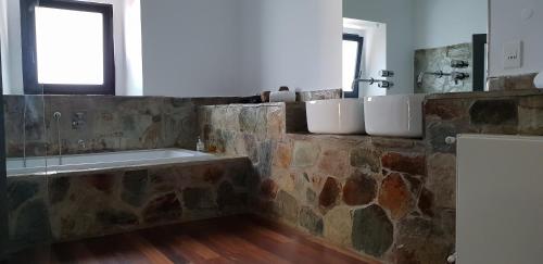 y baño con pared de piedra y bañera. en Herdade Ribeira de Borba, en Vila Viçosa