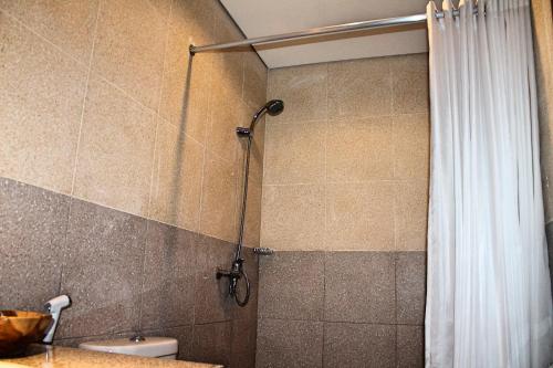 a shower in a bathroom with a shower curtain at Werkudara Guest House in Ubud