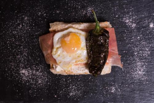 an egg on top of a piece of bread with a pepper on it at The Town House in Marbella