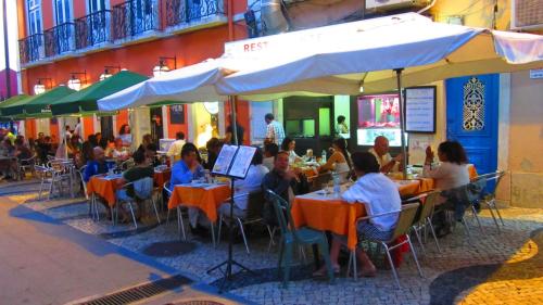 a group of people sitting at tables outside a restaurant at TEJO HOUSE RIVER Lisbon (Cacilhas) in Almada