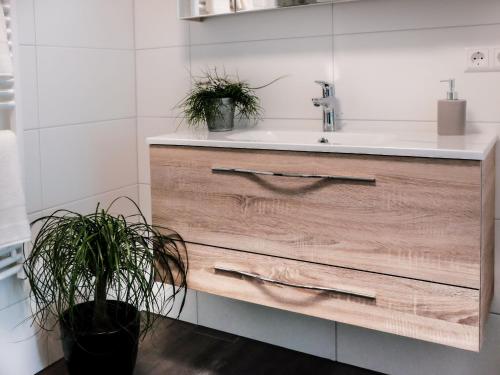a bathroom with a sink and a wooden drawer at Ferienwohnungen Giedensbach in Oberkirch