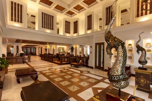 a lobby of a hotel with chairs and tables at Viangbua Mansion in Chiang Mai