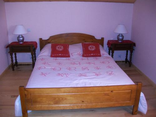 a bedroom with a bed with red pillows on it at le velan in Giez