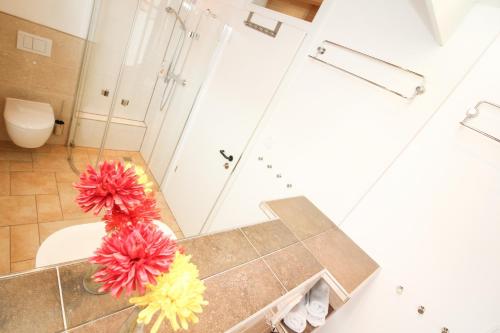 グレートジールにあるLogierhaus-Greetsiel 1のバスルーム(カウンターに赤と黄色の花を飾る)
