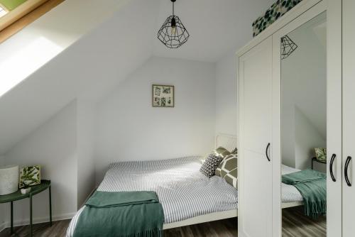 a small bedroom with a bed and a mirror at Studio Kopernika in Iława