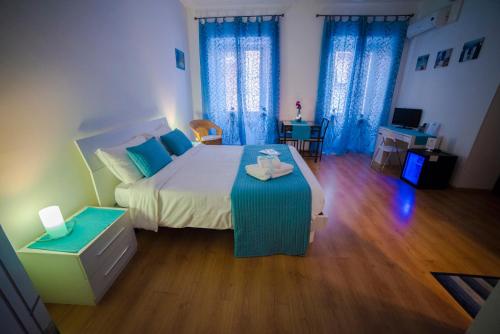 a bedroom with a large bed with blue curtains at Galleria Frascati Rooms and Apartment in Frascati