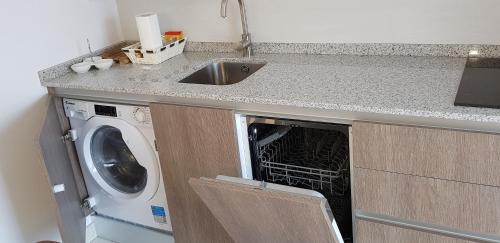 a kitchen with a washing machine under a counter at Apartamentos Miradores del Isasa in Herce