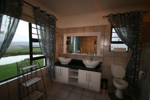 a bathroom with two sinks and a large window at Dusk to Dawn Guesthouse in Piet Retief