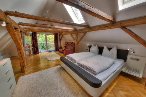 - une chambre avec un lit dans une pièce dotée de poutres apparentes dans l'établissement Hotel - Pension & Gaststätte "Alter König", à Hettstedt