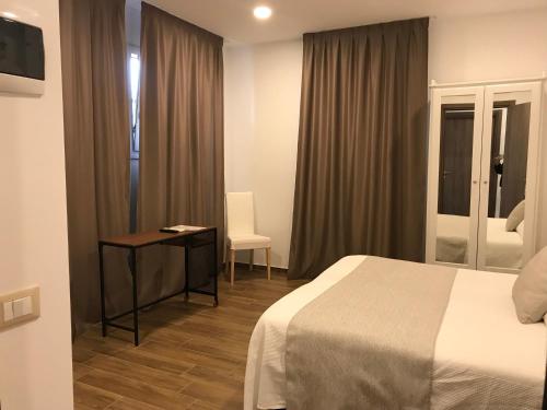 a hotel room with a bed and a desk and a window at Hotel Cambogia in Zibido San Giacomo