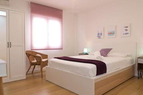 1 dormitorio blanco con 1 cama y 1 silla en Valencia Modern Beach Apartment, en Valencia
