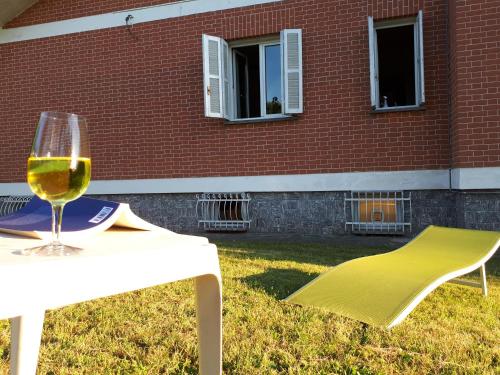 a glass of wine sitting on a table in front of a building at B&B Tre Confini in Giaveno