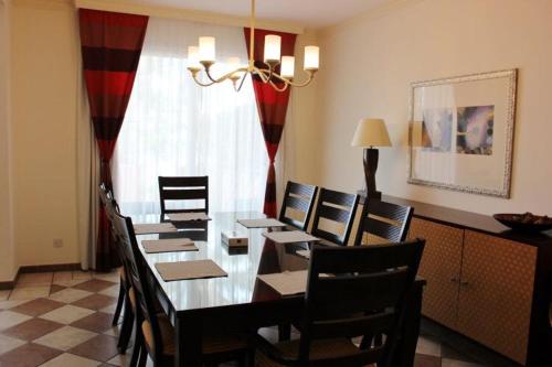 a dining room with a long table and chairs at Seashell Julai'a Hotel & Resort Family resort in Al Qulay‘ah