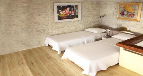 a room with two beds and a painting on the wall at Villa Kardiani in Kardhianí