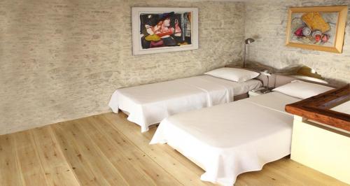 KardhianíにあるVilla Kardianiのベッド2台が備わる客室で、壁には絵画が飾られています。