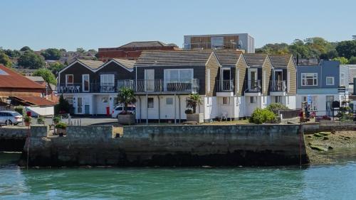 a group of houses next to a body of water at Aisla Cottage • East Cowes • Isle of Wight in East Cowes