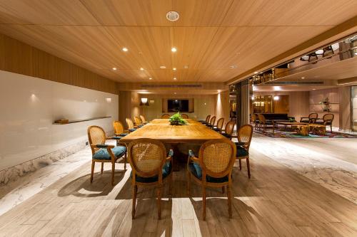 a dining room with a large wooden table and chairs at Inhouse Hotel Grand in Taichung