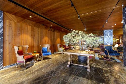 a room with chairs and a table with a tree in it at Inhouse Hotel Grand in Taichung