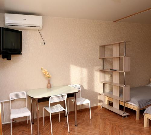 ウリヤノフスクにある1-комнатная меблированная квартира с балконом в центре Ульяновска – посуточноのテーブル、椅子、ベッドが備わる客室です。