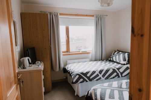 een kleine slaapkamer met twee bedden en een raam bij Greenbank Bed & Breakfast in Montrose