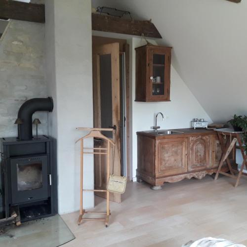 a kitchen with a wood stove and a sink at Petersholm in Odder