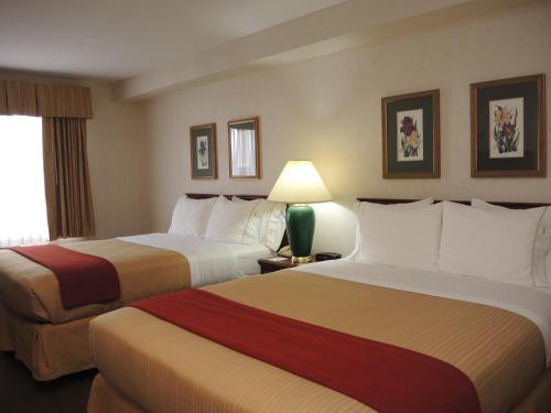 A bed or beds in a room at Evergreen Inn & Suites