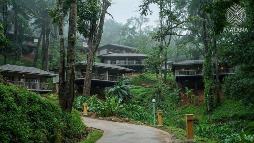a building in the middle of a forest at Ayatana Coorg in Somvārpet