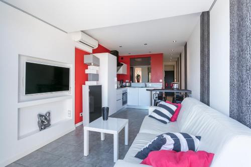 un salon avec un canapé blanc et une télévision dans l'établissement Garden Port nature, au Cap d'Agde