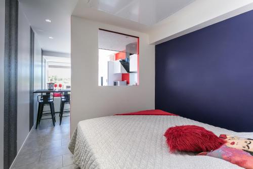 - une chambre avec un lit et un mur bleu dans l'établissement Garden Port nature, au Cap d'Agde