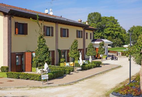 a building with tables and chairs in front of it at Agriturismo B&B Corte Tonolli in Valeggio sul Mincio