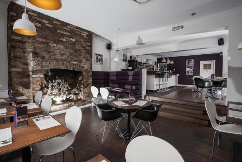 un ristorante con tavoli, sedie e un camino di The Crown Rooms Newmarket a Newmarket