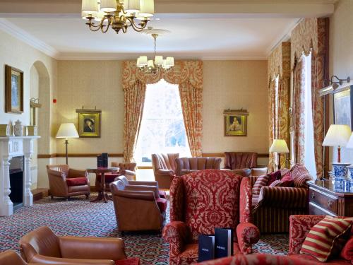 a living room with couches and chairs at Macdonald Crutherland House in East Kilbride