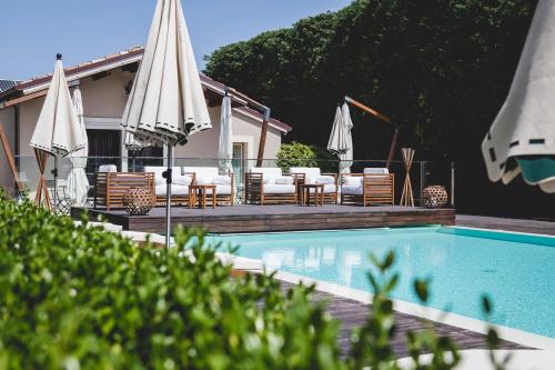 a swimming pool with umbrellas and chairs next to a house at San Giovanni Relais in San Giovanni in Marignano